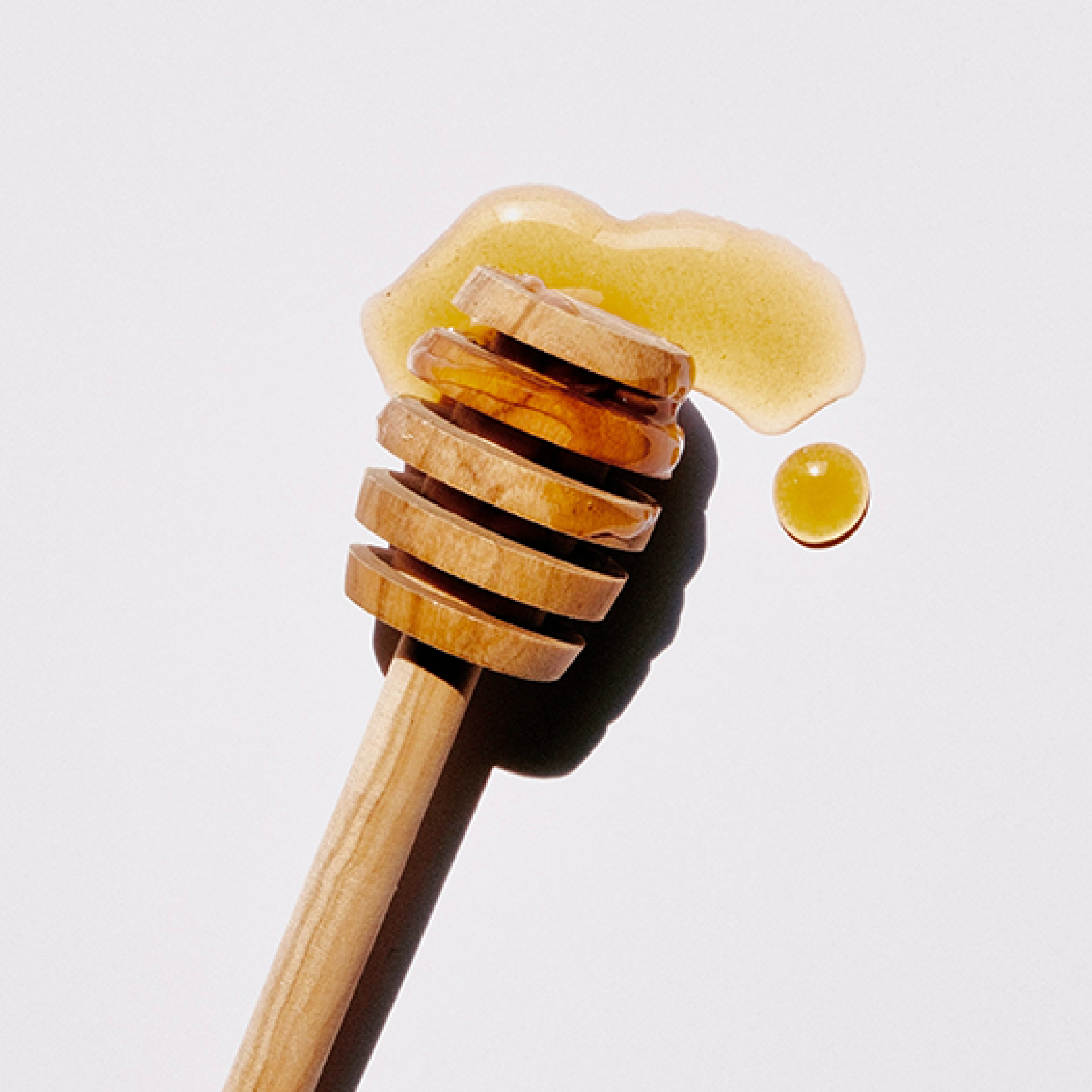 Honey dripping on a honeycomb  depicts the smell of KHANE Honey Leather Perfume.